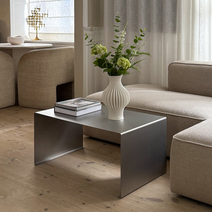 Angled view of the Elegance Coffee Table with a vase placed on top.