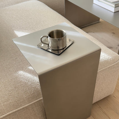 Angled top view of the Elegance Side Table placed next to a sofa, seen from the left