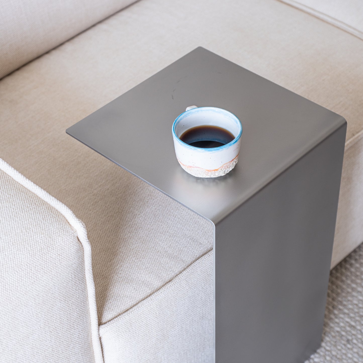 Top view of the Elegance Side Table in a new living room with coffee in a ceramic cup.