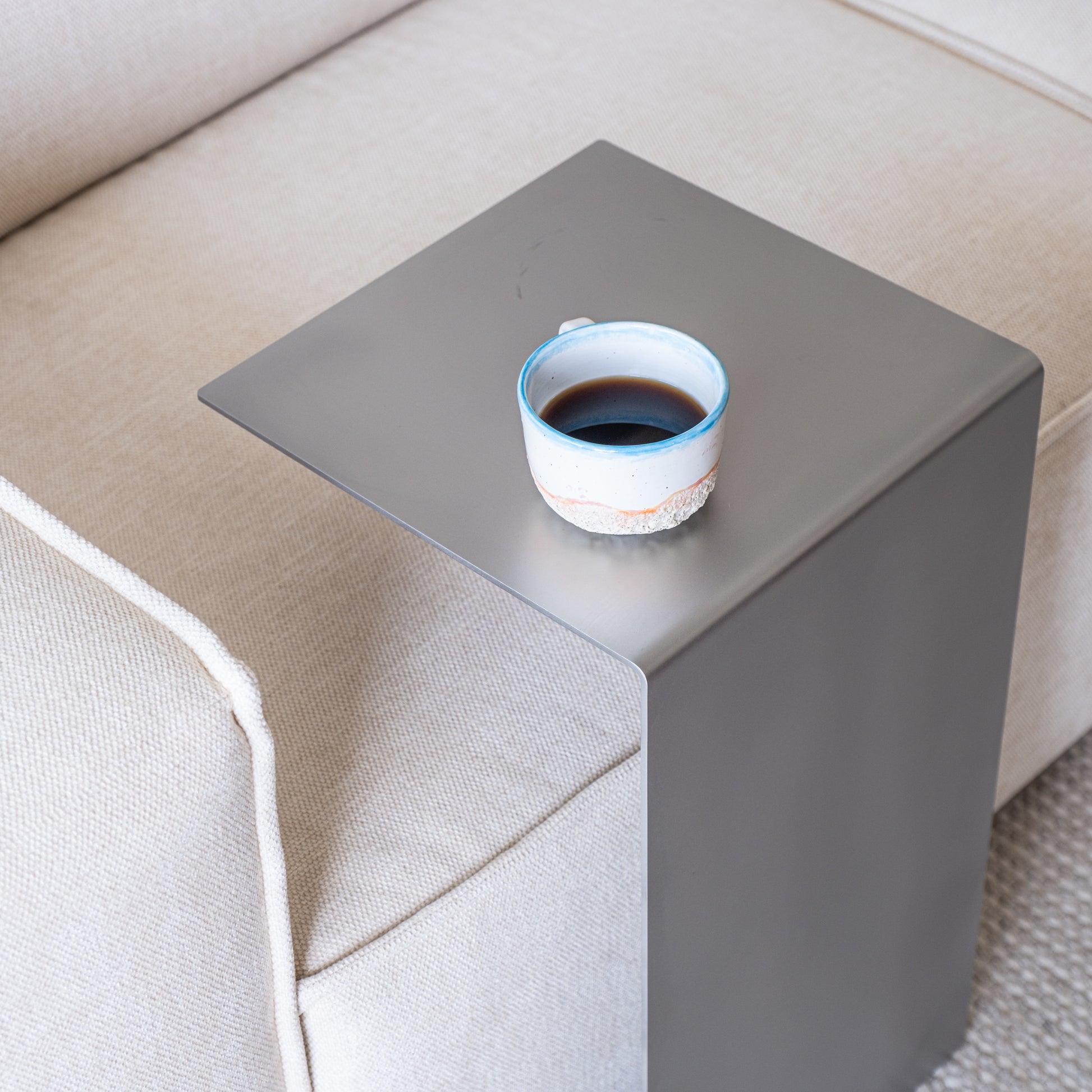 Top view of the Elegance Side Table in a new living room with coffee in a ceramic cup.